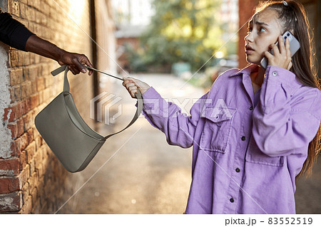 unrecognizable african thief man rob woman on street at day time while female was walking alone 83552519