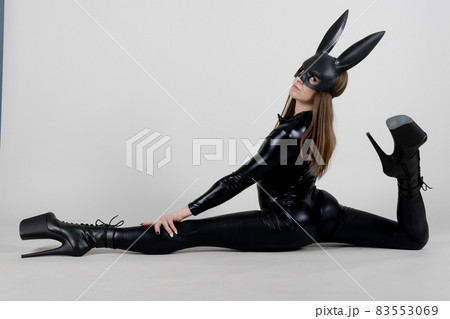 Sexy beautiful woman pole dancer posing in latex costume on background. Easter bunny concept. 83553069