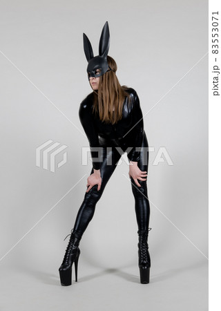 Sexy beautiful woman pole dancer posing in latex costume on background. Easter bunny concept. 83553071