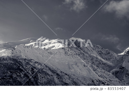 Black and white snowy sunlight mountains, view from off piste slope Black and white snowy sunlight mountains, view from off piste slope 83553407