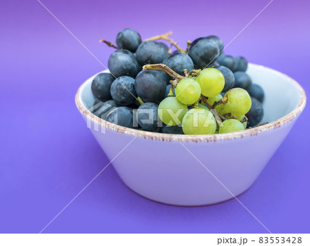 Red and white grapes, purple background. Top view, vintage,wine concept 83553428