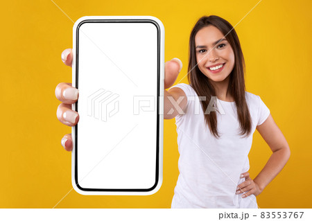 Woman showing white empty smartphone screen close up to camera Woman showing white empty smartphone screen close up to camera 83553767