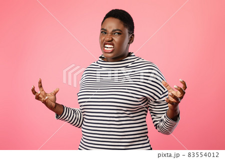Angry Plus Size African American Lady Expressing Aggression Over Pink Background 83554012