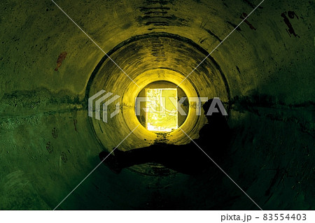 Man sitting in underground concrete tunnel Man sitting in underground concrete tunnel 83554403
