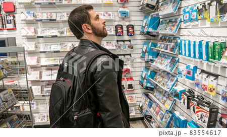 Gamer man shopping for gaming accessories and games and Gamestop, Munich, Germany Gamer man shopping for gaming accessories and games and Gamestop, Munich, Germany 83554617
