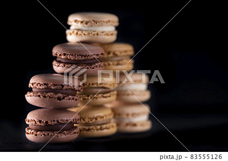 chocolate, coffee, vanilla, lemon and strawberry macaroons on black background chocolate, coffee, vanilla, lemon and strawberry macaroons on black background 83555126