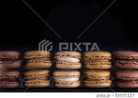 chocolate, coffee, vanilla, lemon and strawberry macaroons on black background chocolate, coffee, vanilla, lemon and strawberry macaroons on black background 83555127