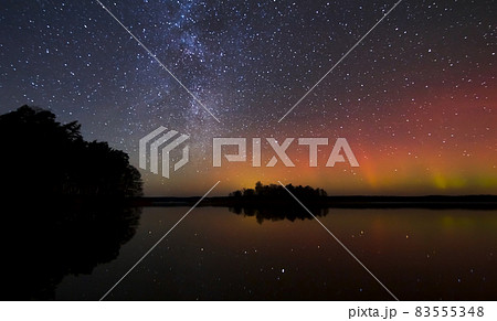 Milky way and Northern lights - Aurora borealis over the lake in Lithuania 83555348