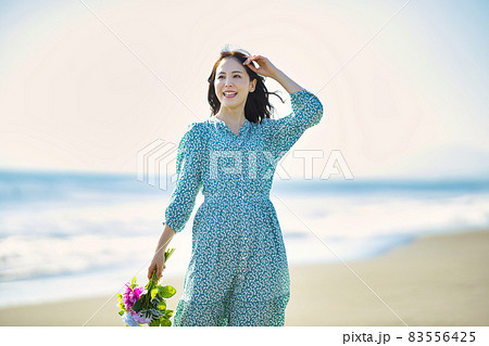 砂浜を歩く若い女性 83556425