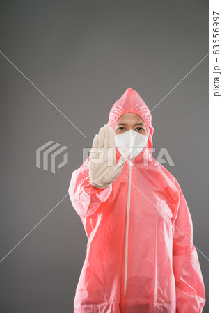 Health worker wear personal protective equipment with palms forward as a stop gesture Health worker wear personal protective equipment with palms forward as a stop gesture 83556997