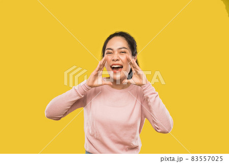 portrait of woman screaming holding two hands near mouth 83557025