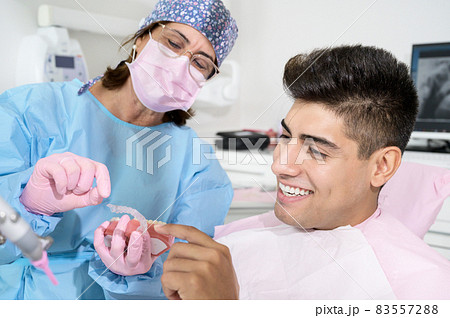 Dentist shows invisible braces aligner. Dental consultation in an orthodontic clinic 83557288