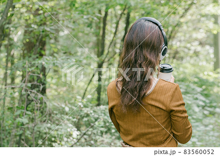 新緑の中で音楽を聴く女性 ヘッドフォンで音楽を聴く女性 新緑の中で音楽を聴く女性 ヘッドフォンで音楽を聴く女性 83560052