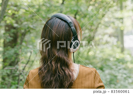 新緑の中で音楽を聴く女性 ヘッドフォンで音楽を聴く女性 新緑の中で音楽を聴く女性 ヘッドフォンで音楽を聴く女性 83560061