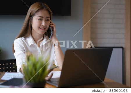 When he offers the major project, a serious business woman awaits confirmation from her partner by cell phone When he offers the major project, a serious business woman awaits confirmation from her partner by cell phone 83560198