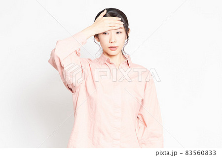 発熱でおでこに手を当てる女性 83560833