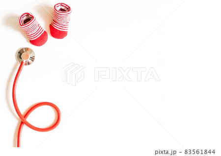 Children's doctor concept - red little baby shoes with stethoscope on white background top view copy space 83561844