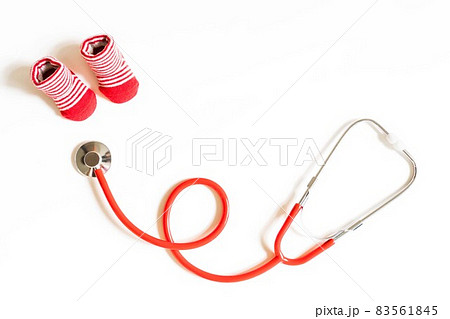 Children's doctor concept - red little baby shoes with stethoscope on white background top view copy space 83561845