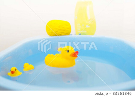 Yellow baby ducks swim in a blue basin. Concept for washing baby clothes or bathing.Soft and Selective focus. 83561846