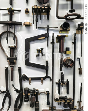 Many tools for repairing motorcycles hanging on wall in workshop. Set Craftsman tool , mechanical tools. Professional mechanic using different tools for working in motorbike repair service at garage. Many tools for repairing motorcycles hanging on wall in workshop. Set Craftsman tool , mechanical tools. Professional mechanic using different tools for working in motorbike repair service at garage. 83562510