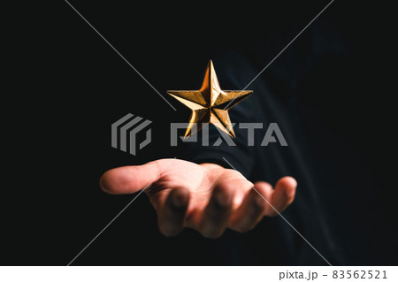 golden star rating on hand in dark background golden star rating on hand in dark background 83562521