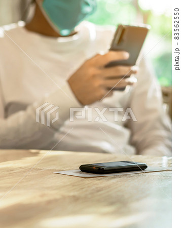Queue Wireless Calling System Restaurant or Pager Customers System with invoice on table with blur image of man wear protective face mask using cellphone in background. Alarm signal when food is done. Queue Wireless Calling System Restaurant or Pager Customers System with invoice on table with blur image of man wear protective face mask using cellphone in background. Alarm signal when food is done. 83562550