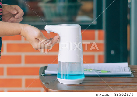 Automatic alcohol dispenser for cleaning hand to prevent the spreading of Coronavirus (Covid-19) on table before entrance to cafeteria. Healthcare concept. New normal lifestyle. Selective focus 83562879
