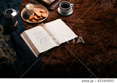 Coffee cup, book and tray of cookies on carpet. Coffee cup, book and tray of cookies on carpet. 83564005