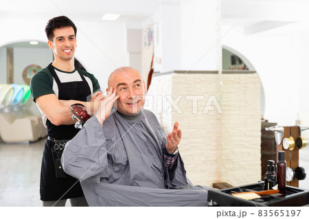 Hairdresser during washing head of positive man after shaving 83565197