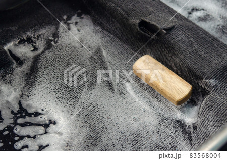 Wash the car carpet.Detailing on interior of modern car.Clean by using a brush and cleaning solution on the car carpet. Wash the car carpet.Detailing on interior of modern car.Clean by using a brush and cleaning solution on the car carpet. 83568004