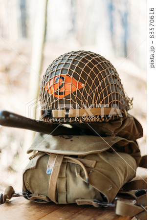 Metal Helmet Of United States Army Infantry Soldier At World War II. Helmet On Camping Tent In Forest Camp Metal Helmet Of United States Army Infantry Soldier At World War II. Helmet On Camping Tent In Forest Camp 83570616