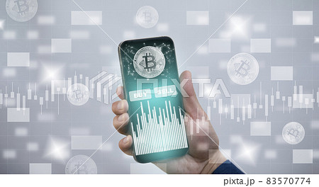 Smartphone with Bitcoin chart on-screen among piles of Bitcoin concept. businessman touch on mobile app screen with big BUY and SELL buttons on the stock market, Cryptocurrency and finance. 83570774