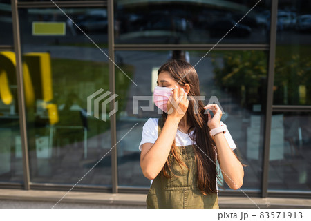 Young woman putting on protective mask for coronavirus prevention. 83571913