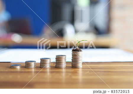 Coins by height lie on the table, green sprout on the money 83572015