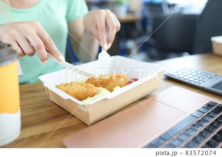 Woman eats in the dining room, disposable tableware Woman eats in the dining room, disposable tableware 83572074