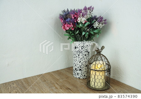 Bird Cage with Candle light and flower decoration on wooden background 83574390