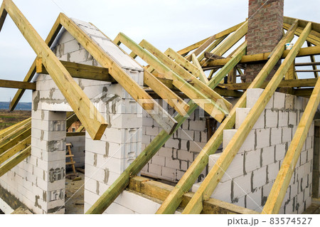 Aerial view of a private house with aerated concrete brick walls and wooden frame for future roof. 83574527