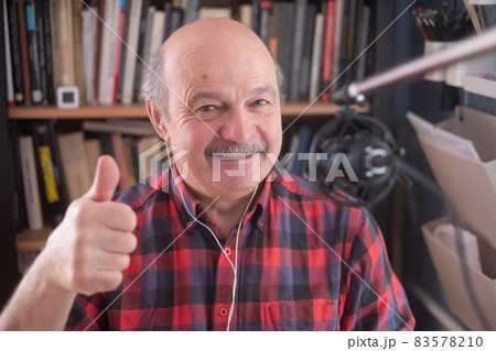 Senior retired man blogger looking at camera recording vlog, smiling old elder grandfather showing thumb up 83578210