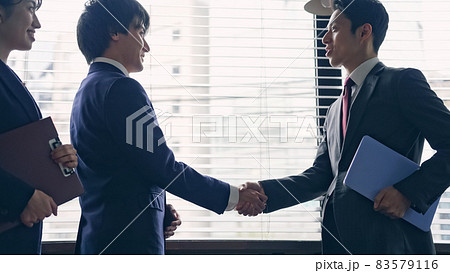 握手する日本人ビジネスグループ 83579116
