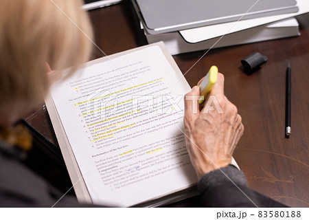 Hand of mature female lawyer highlighting lines of contract text Hand of mature female lawyer highlighting lines of contract text 83580188
