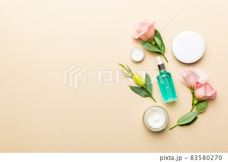 Composition with cosmetic products and beautiful roses on color background. Copy space, flat lay 83580270