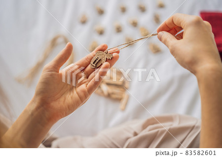 Woman making Christmas advent calendar. Pouches on a rope 83582601