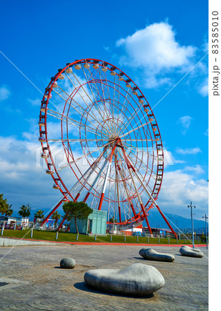 The Ferris wheel is red and white against the sky 83585010