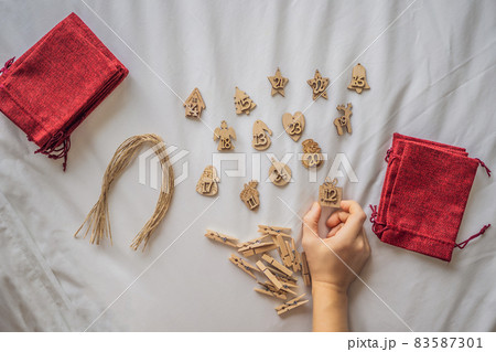 Woman making Christmas advent calendar. Pouches on a rope 83587301