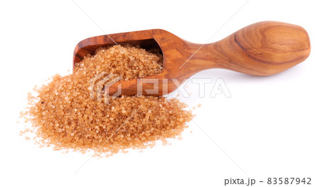Brown sugar in wooden scoop, isolated on white background. Heap of cane sugar crystals. 83587942