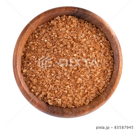 Brown sugar in wooden bowl, isolated on white background. Heap of cane sugar crystals. Top view. 83587945