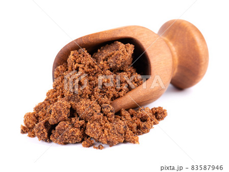 Muscovado sugar in wooden scoop, isolated on white background. Barbados sugar, khandsari or khand. 83587946