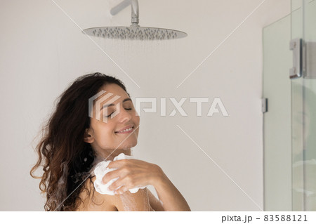 Young beautiful woman washes in the shower with washcloth 83588121
