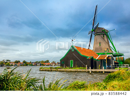 Dutch Landscape -  village with a windmill and a house.   Agricultural Historical Landscape. Tourism. Popular Holland, Netherlands, Europe. 83588442