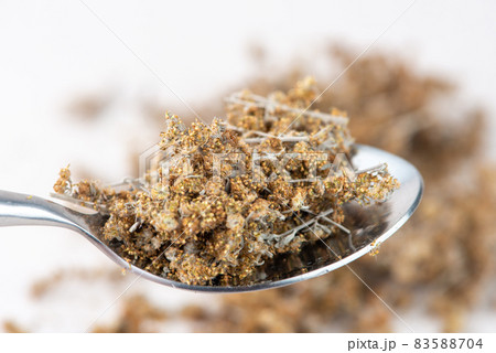 Spoon with dried wormwood herb isolated on white background. Cose up. Spoon with dried wormwood herb isolated on white background. Cose up. 83588704